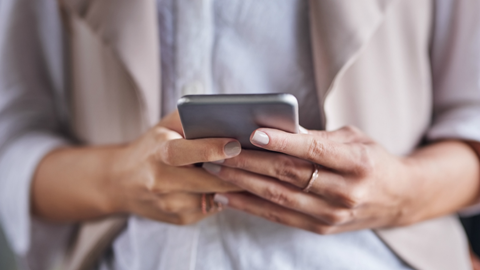 Iphone in handen van een persoon die de opslag van zijn gegevens probeert te beheren.